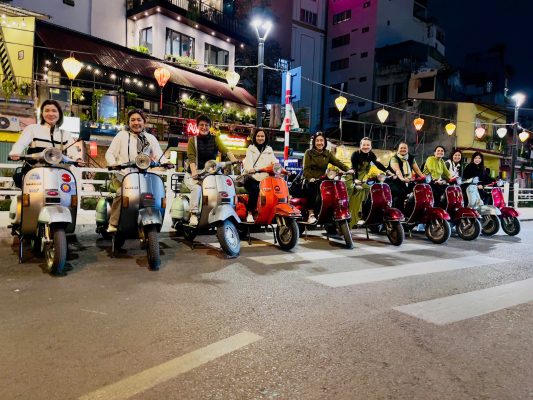 Cruise through the glowing streets of Hanoi on a vintage Vespa.